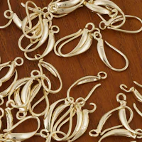 a bunch of gold plated hooks on a wooden table