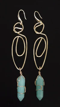 a pair of gold plated earrings with a turquoise stone