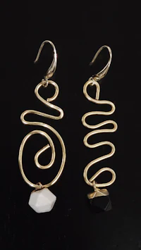 a pair of gold - plated earrings with black and white stones