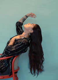 a woman with long hair laying on a chair