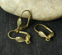 three gold plated hooks on a rock